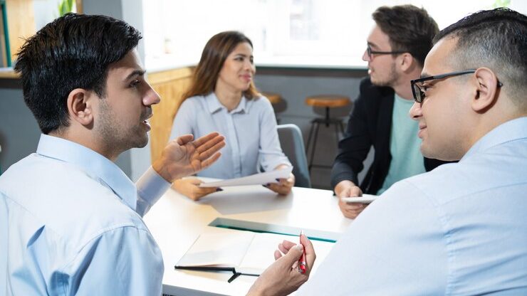 Cuatro personas conversando alrededor de una mesa